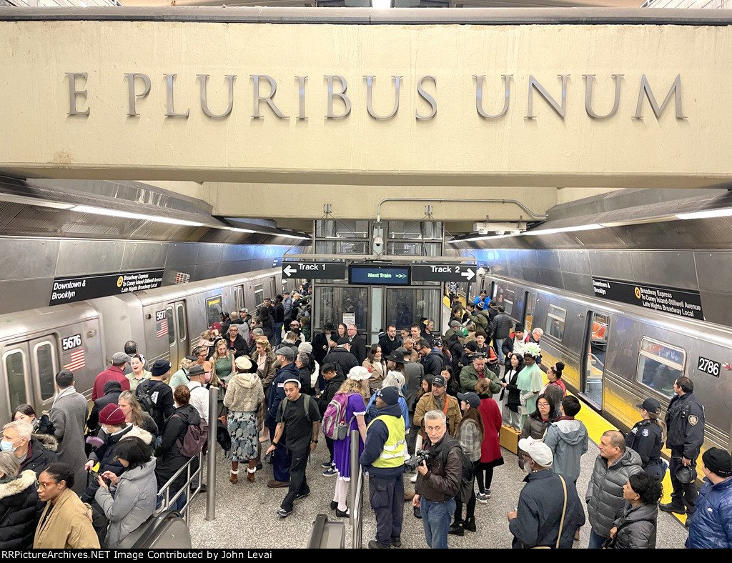 The crowd at 96th St Station surrounded by two regular Q trains 